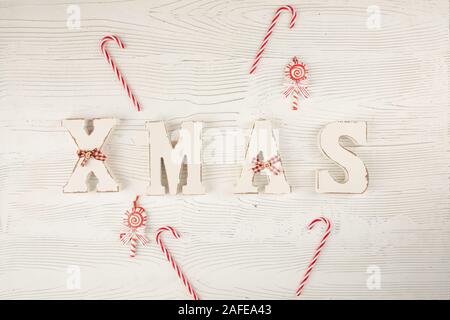 Title Xmas with candy on wooden white blue background. Christmas festive card, holidays Stock Photo