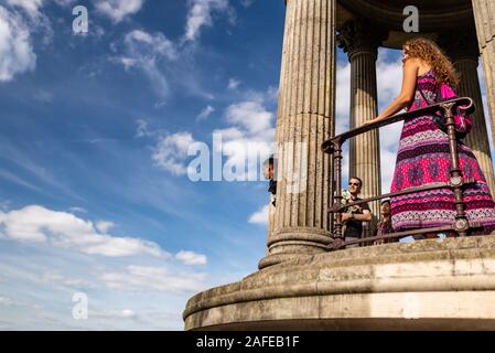 Paris, France - June 16, 2017: Visitors looking at the view from the temple of the Sybil in Buttes Chaumont Park seen through tree branches, taken on Stock Photo