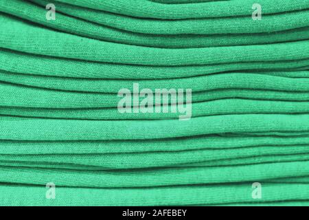 clothes stacked close-up, fabric texture, bright colors, neat green stacks. Stock Photo