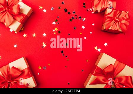 Several gift boxes with bows on a red background. Stock Photo