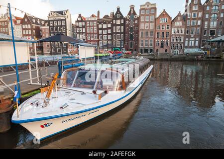 Amsterdam, Netherlands - February 24, 2017: Sightseeing tourist boat moored at the canal in historical center of Amsterdam Stock Photo