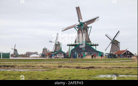 Zaanse Schans, Netherlands - February 25: Tourists walk near old windmills and wooden houses of Zaanse Schans Stock Photo
