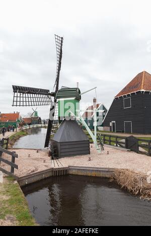Zaanse Schans, Netherlands - February 25: Small windmill and old wooden houses of Zaanse Schans town, it is one of the popular tourist attractions of Stock Photo