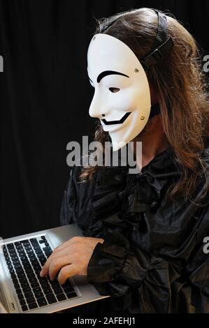 member of the Anonymous hacker group in front of the laptop Stock Photo
