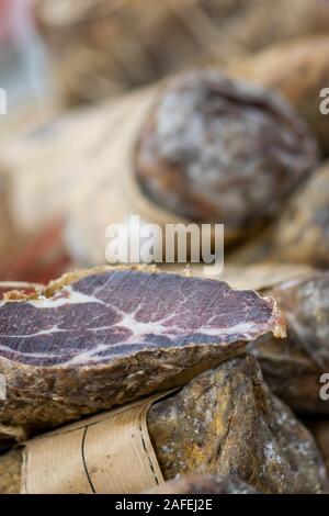 Macro shot of various sausages in food market. Cut of the sausage with white tendons is in camera focus Stock Photo
