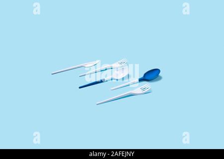 Dangerous and needed two plastic spoons. Environmental problem of plastic rubbish pollution. Flat lay, top view, copy space. Stock Photo