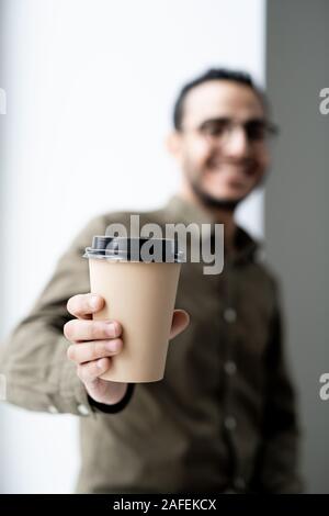 Disposable glass of hot coffee in hand of young successful businessman Stock Photo