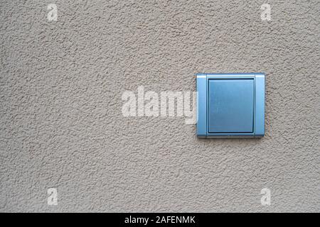silver light switch on yellow outdoor wall Stock Photo