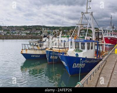 A couple of blue and red fisher boats in the harbour of Howth (Ireland), near Dublin, on an overcast summer day. Stock Photo