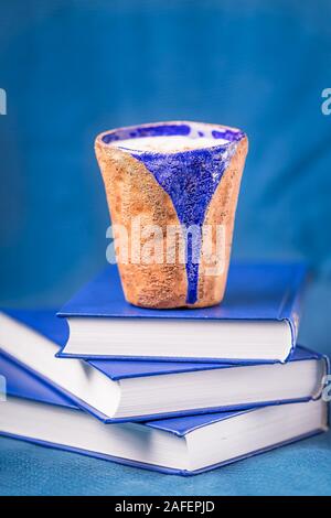 Homemade coffee latte with true ceylon cinnamon and three books on blue background. Shades of blue. Top view, copy space Stock Photo
