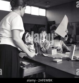 1960s, historical, a female primary school teacher with children in the classroom, England, UK. Stock Photo