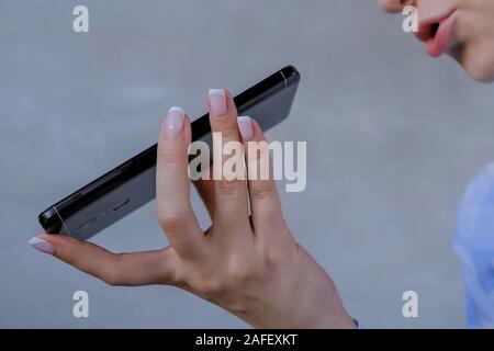 Woman holding smartphone and using voice recognition function Stock Photo