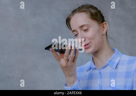 Woman holding smartphone and using voice recognition function Stock Photo