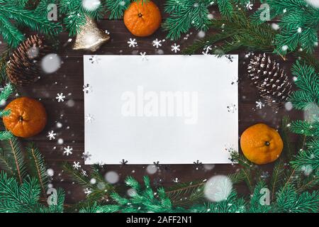 Christmas background for greetings, fir branches, paper, snowflakes, cones, bell citrus and decor Stock Photo