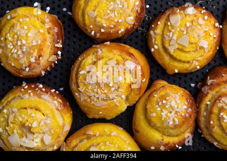 Close-up of a background of Swedish traditional christmas saffron bun Lussebullar on a perforated oven tray. The buns are freshly made and homemade an