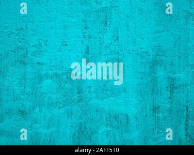 Fragment of solid concrete wall painted in turquoise color with many tine details, close-up Stock Photo