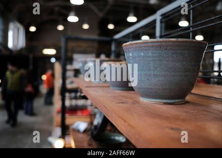 Shelf of plain stone coloured bowls at the Ottawa Potters Guild annual Holiday Sale, Horticulture Building, Lansdowne Park, Ottawa, Ontario, Canada. Stock Photo