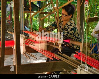 A  female weaver producing silk fabric on a traditional hand loom on Silk Island / Koh Dach near Phnom Penh in Cambodia Stock Photo