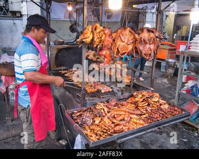 A trader cooks kebab skewers of meat over hot coals to sell as freshly cooked, hot, street food in Phnom Penh, Cambodia. Stock Photo
