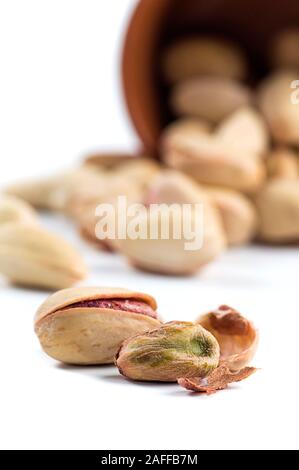 Pistachio and Cashew Nuts in clay pots on white background Stock Photo