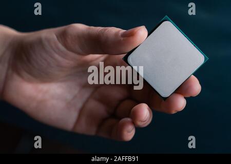Hand holding CPU. Coonsumer 7 nanometer desktop CPU, processoor. Informatic chip, PC component. Stock Photo