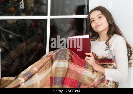 Christmas story that grabs imagination. Little girl read and imagine. Book offers scope for childs imagination. Cute dreamer. Kids imagination and fantasy. Imagination has no limit. Stock Photo