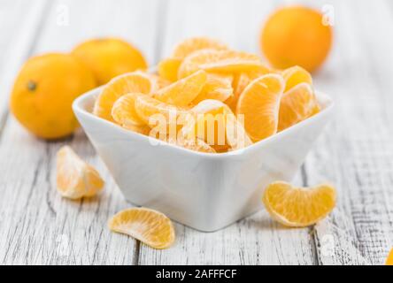 Raw Tangerine pieces (close-up shot) on vintage background Stock Photo