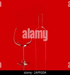 Empty wine glass and a bottle isolated on red background. Elegant red wine glass and a wine bottle. Valentine's day, Birthday concept. Stock Photo