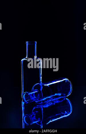 Empty classic blue color bottles isolated on dark background. Valentine's day, Birthday concept. Classic Blue color of the Year 2020 inscription. Stock Photo