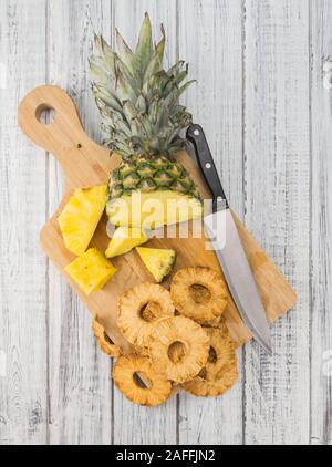 Pineapple rings (dried) on rustic wooden background as close-up shot Stock Photo