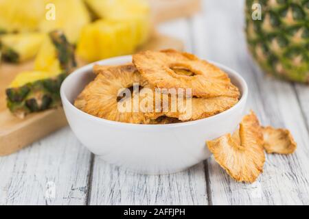 Pineapple rings (dried) on rustic wooden background as close-up shot Stock Photo