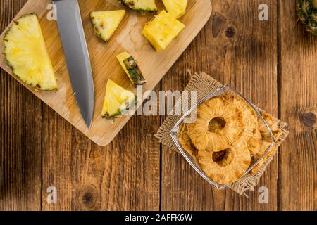 Pineapple rings (dried) on rustic wooden background as close-up shot Stock Photo