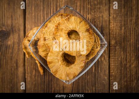 Pineapple rings (dried) on rustic wooden background as close-up shot Stock Photo