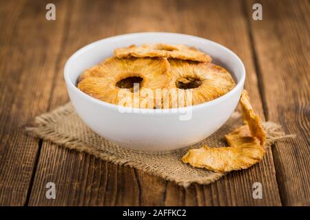 Pineapple rings (dried) on rustic wooden background as close-up shot Stock Photo