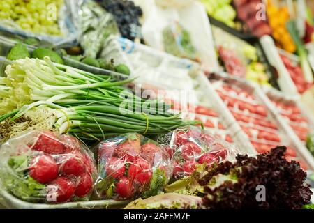 Background image of various vegetables on stand in farmers market, onion, radish and greens in focus, copy space Stock Photo