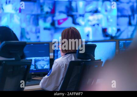 In the System Control Room, Technical Operator Works at His Workstation with Multiple Displays, Security guard working on multiple monitors. Stock Photo