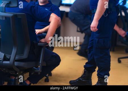Security officers in wearing their uniforms standing and chatting in the secret service center. Stock Photo