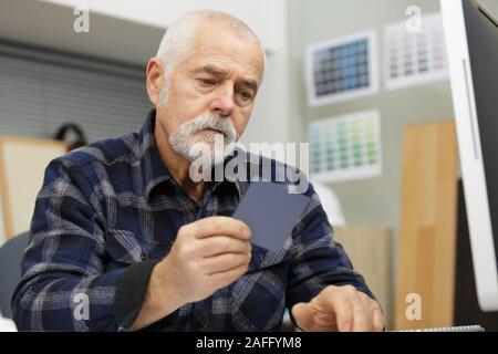 senior man is doing paperwork in her stock factory Stock Photo