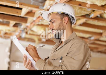 smart pensive builder thinking about something indoors Stock Photo