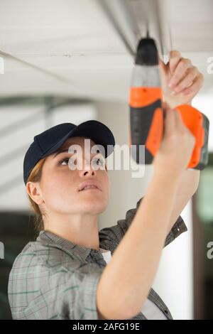 woman installing blinds with screwdriver Stock Photo