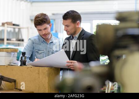 man working with apprentice in printing house Stock Photo