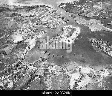 Aerial view of the Naval Operating Base, Pearl Harbor, looking southwest on 30 October 1941. Ford Island Naval Air Station is in the center, with the Pearl Harbor Navy Yard just beyond it, across the channel. The airfield in the upper left-center is the Army's Hickam Field. Stock Photo