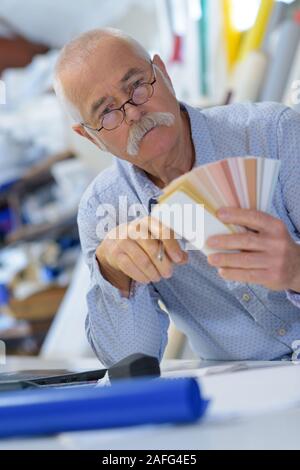 elderly man holding a color swatch Stock Photo - Alamy