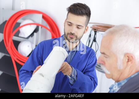 senior technician and younger worker Stock Photo