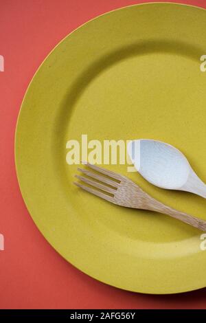 Bamboo cutlery on a yellow plate. Stock Photo