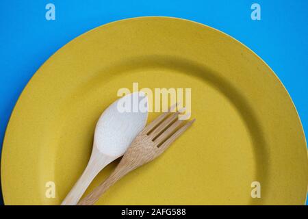 Bamboo cutlery on a yellow plate. Stock Photo