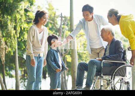 happy asian three generation family having fun outdoors in park Stock Photo