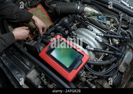 Checking the condition of the surface of the engine cylinders using an endoscope camera with a wireless display showing scratches on the unit for over Stock Photo