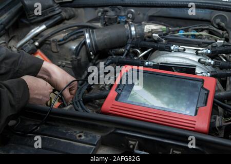 Checking the condition of the surface of the engine cylinders using an endoscope camera with a wireless display showing scratches on the unit for over Stock Photo