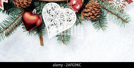 Christmas background red, border, branches of a Christmas tree, heart, pine cone, cinnamon, ball, gift Stock Photo